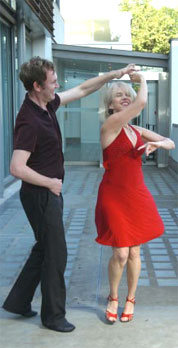 Lloyd spinning Carol Ann in a red knee length dress
