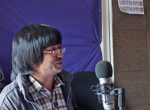 Head and shoulders shot of Kishor  speaking into the microphone