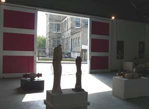 View of some sculptures looking out through open shutters to St Mary's Primary school