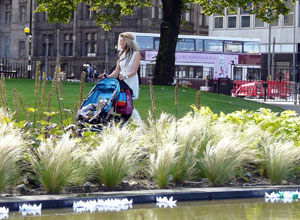 Woman with buggy walks past the floating lotuses