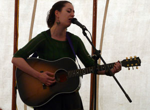 Young woman singing with an acoustic guitar
