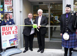 Manager Billy Stirling with North & Leith MP, Mark Lazarowicz cutting the ribbon to the accompaniment of the pipes