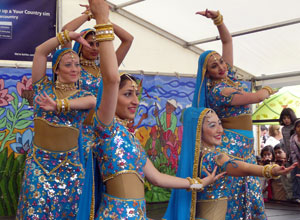 Four women in blue holding  poses in formation
