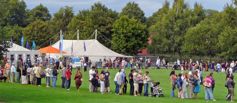 Visitors in a circular queue on the  south side of Pilrig Park with the  Forest Workshop Tent in the background