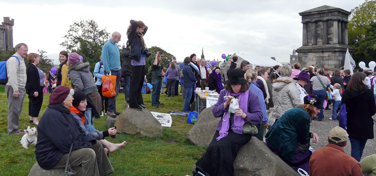 Various people  sitting on boulders and standing chatting