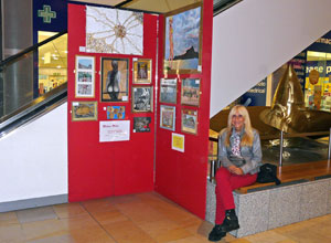 Melissa Milan seated beside her work
