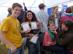 Young people holding up bags with face painting in the foreground