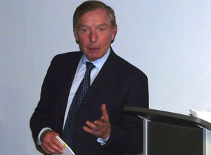 Head and shoulders of Sir Tom Farmer talking and gesturing.