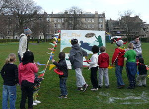 Children throwing frisbees at a target board with Elgin Terrace in the background