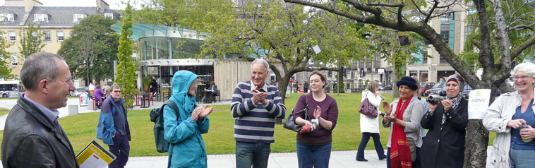 Group of smiling people gathered by the poetry tree with Harvey  Nichols visible in the background
