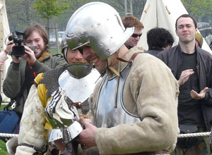 Helmeted man smiling at  the gauntlets that he holds