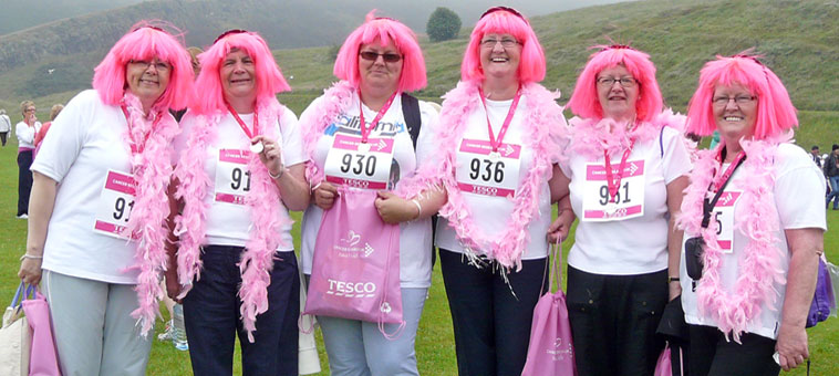 Six women from the Dalkeith and Gorebridge area with  shocling pink Lady Gaga wigs and pink boas  with their Tesco  gift bags at the end of the race