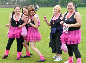 Five women in black with shocking pink tutus