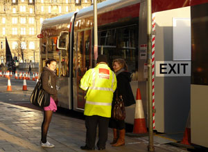 Two young women chatting to a tram attendant