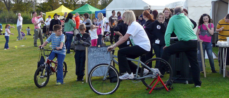 Woman in white tee shirt on a bicycle linked to a microgenerator