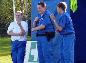 Two men and a woman in blue first aid uniforms doing the mashed potato