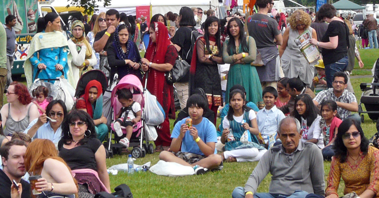 People seated and standing waiting for a show to start on the Garden Stage