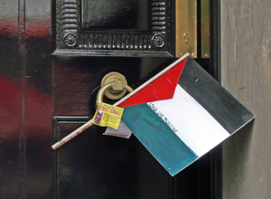 A Palestinian flag with the words "Freedom for Palestine" wedged in the door knocker with a "Boycott Israeli Goods" sticker