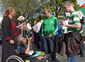 Nabil in his wheelchair holding up a camcorder for Celtic supporters