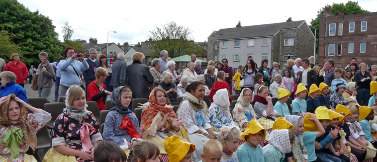 Children seated in fishwives and fishermens outfits in the playground of  Victoria Primary School