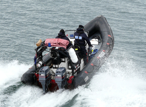Black launch with the stern low throwing up spray