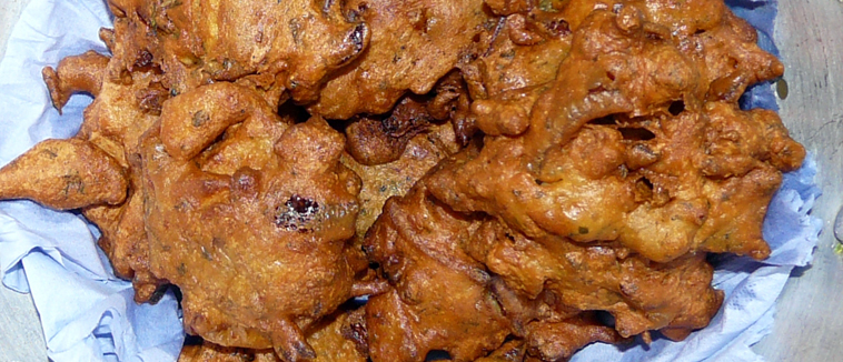 An onion bhaji on blue tissue paper