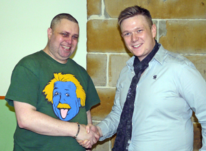 Dave in green tee shirt with cartoon of Einstein shakes hands with Simon