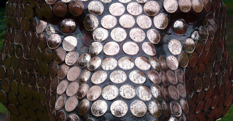 Close up of the face of a fibre glass tiger covered in one pence coins