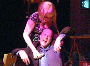 Woman bent over a screaming man with an electical device