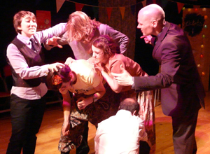 Woman and man arguing around a group of people bundled into a twisted mass