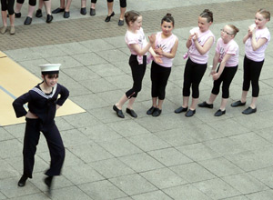 A girl dressed as a sailor dances the hornpipe as five other girls watch on
