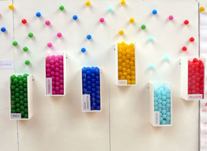 Different coloured balls catalogued in containers - green, pink, blue, yellow, sky and red