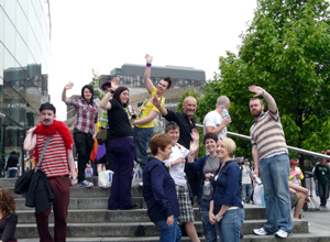 A group of people standing on the steps of the Omni Centre waving