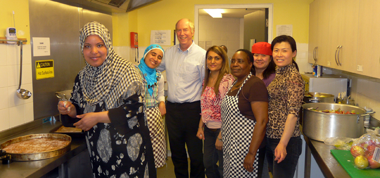 Malcolm Chisholm (in white shirt with six of the World Cafe workers in the kitchen