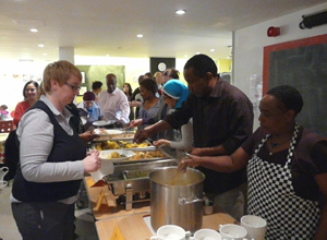A man and a woman serving food from tables