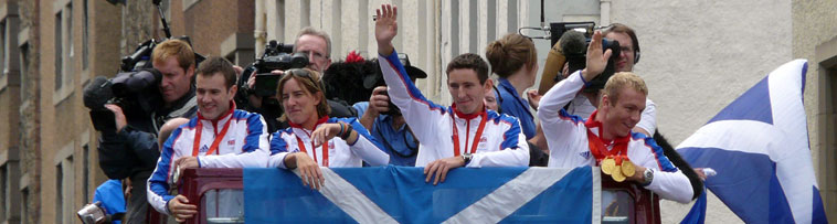 Left to right: Florence, Grainger, Edgar and Hoy on top of the bus in their Team GB strips waving and with Chris holding his three gold medals